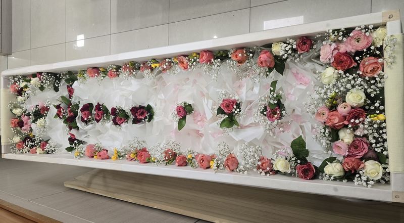 관 전체를 감싸듯 두른 생화 라인